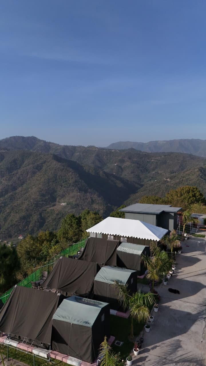 Aerial view showing the full property layout with mountains and blue sky